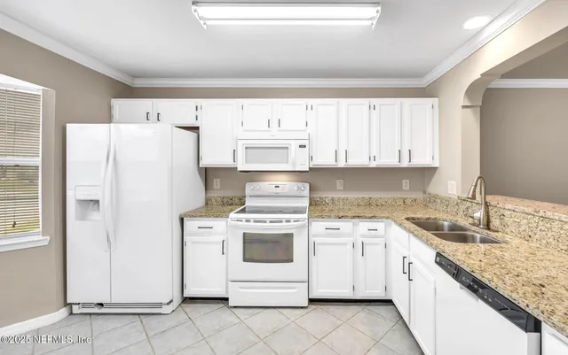 a kitchen with white cabinets and white appliances