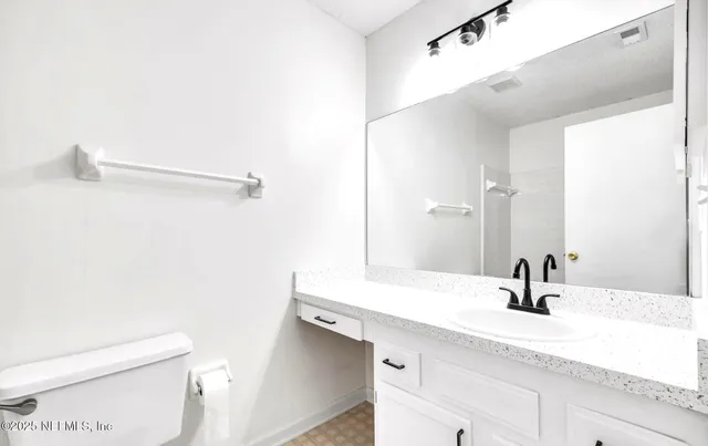 a bathroom with a sink a toilet and a mirror