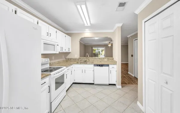 a large white kitchen with cabinets