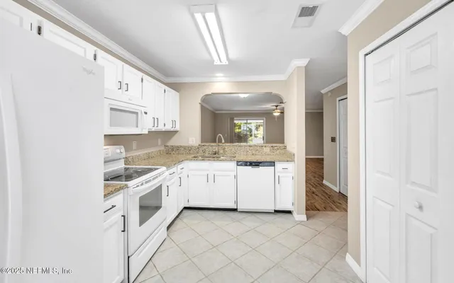a large white kitchen with cabinets