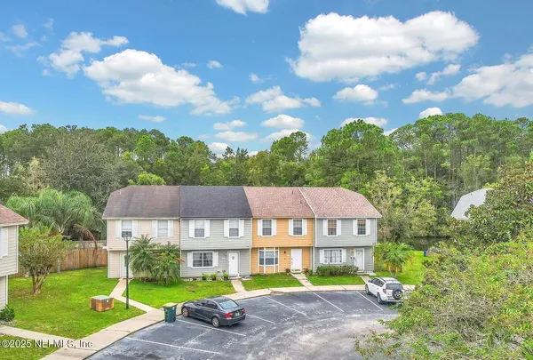 a view of a big house with a big yard and large trees