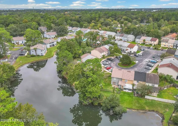 an aerial view of residential houses with outdoor space and river