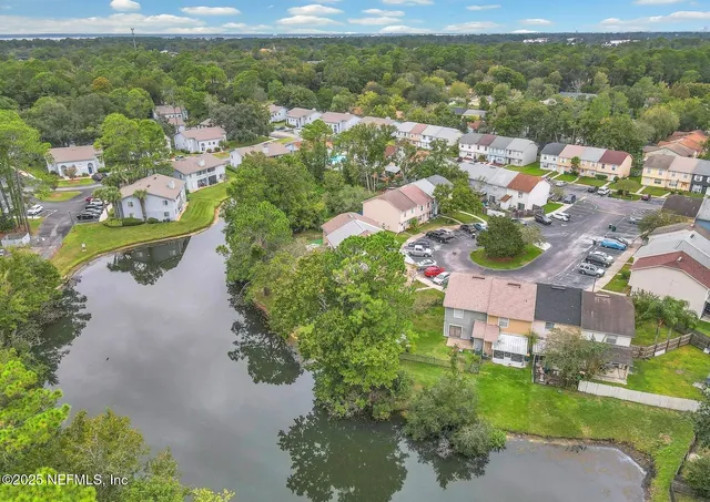 an aerial view of residential houses with outdoor space and river