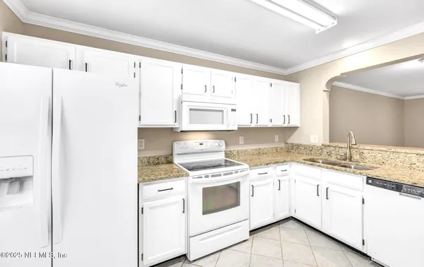 a kitchen with granite countertop white cabinets and white appliances