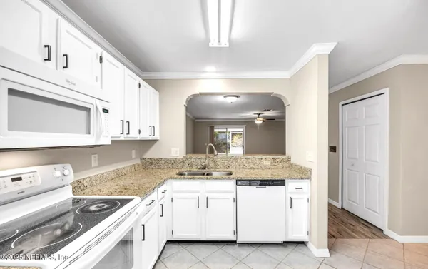 a kitchen with granite countertop a sink stove and cabinets