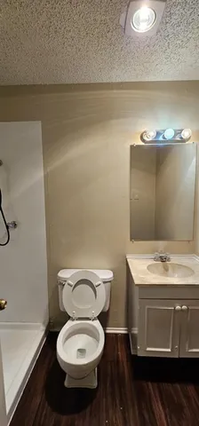 a bathroom with a granite countertop toilet and a sink