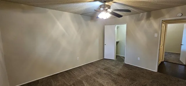 an empty room with closet and a chandelier fan