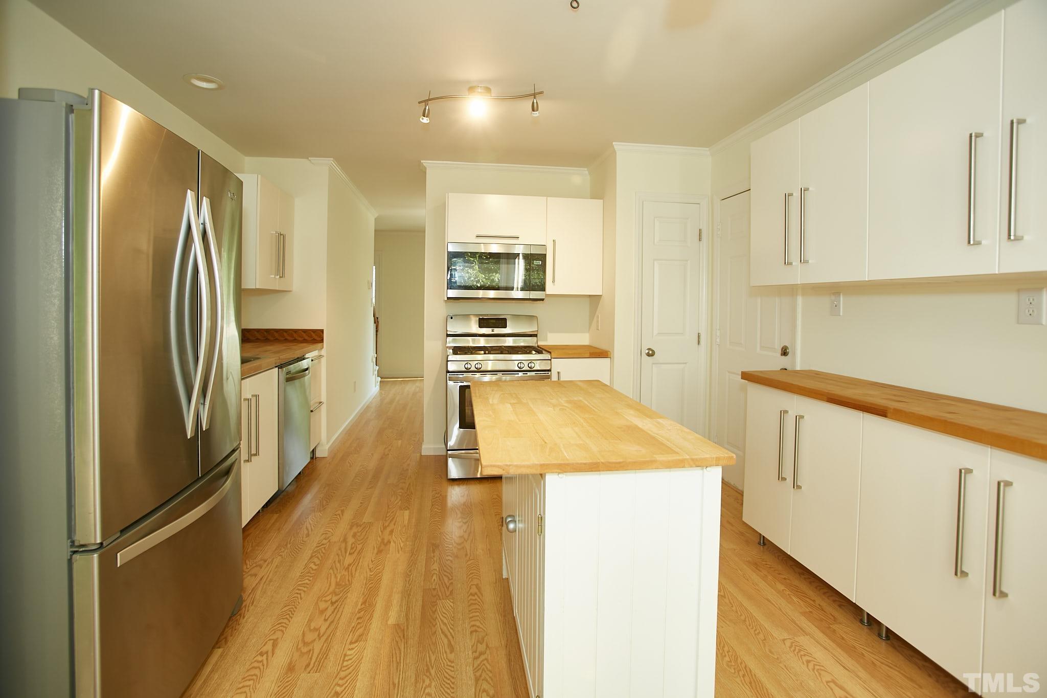 4616 Knightsbridge Way Raleigh, NC 27604 - Photo 12 of 27 a kitchen with white cabinets and stainless steel appliances