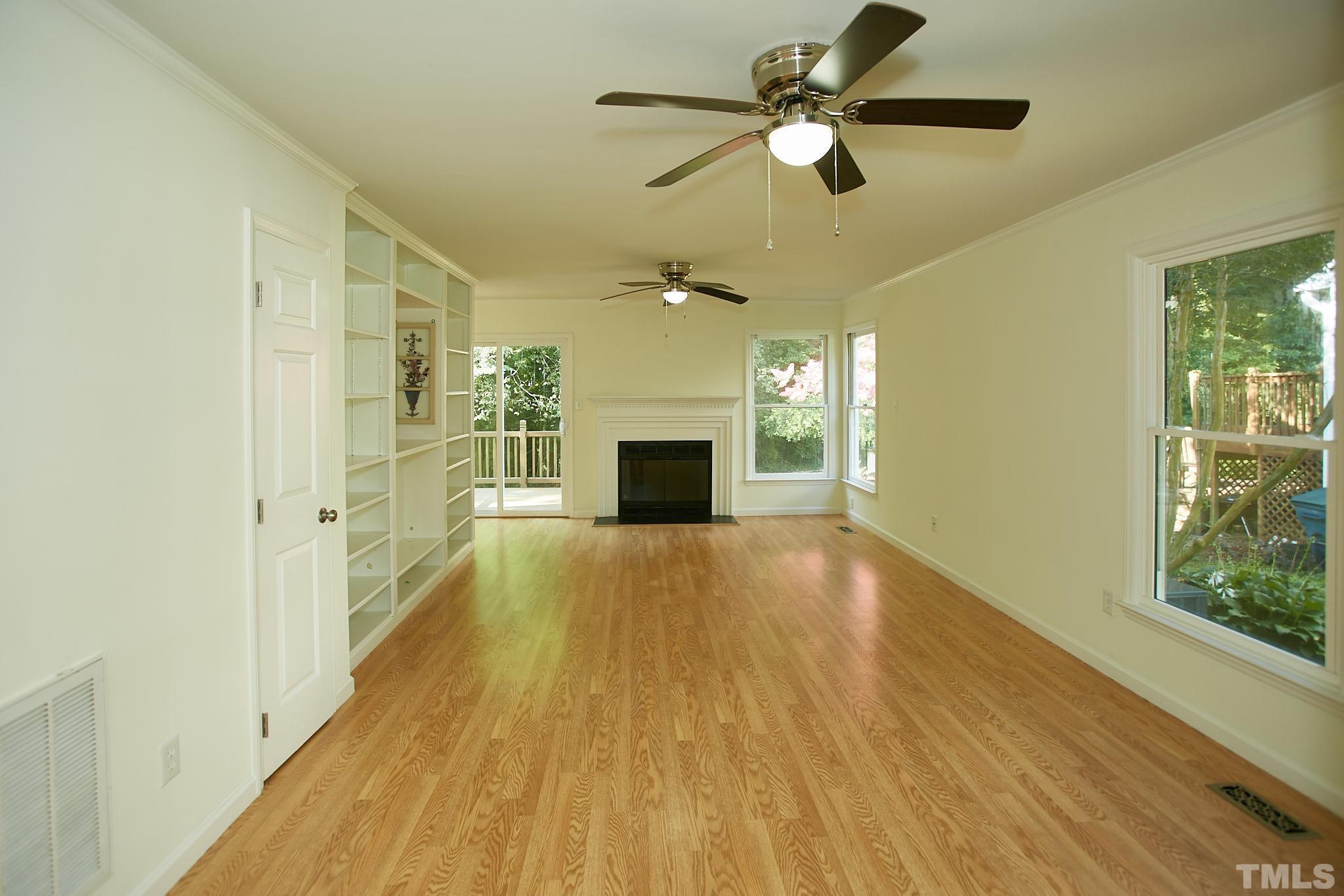 4616 Knightsbridge Way Raleigh, NC 27604 - Photo 7 of 27 a view of a livingroom with a fireplace a ceiling fan and wooden floor