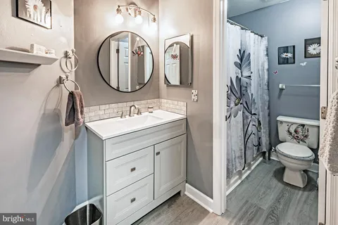 a bathroom with a toilet a sink and a mirror