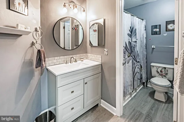 a bathroom with a toilet a sink and a mirror