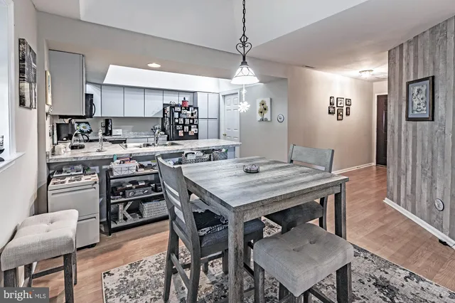 a kitchen with stainless steel appliances granite countertop a stove a refrigerator a kitchen island a dining table and chairs