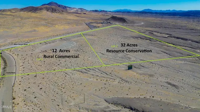 a view of a dry yard with wooden fence