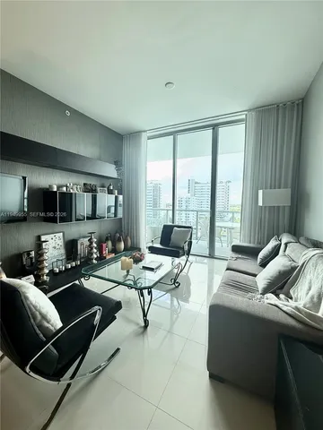 a living room with furniture and a floor to ceiling window