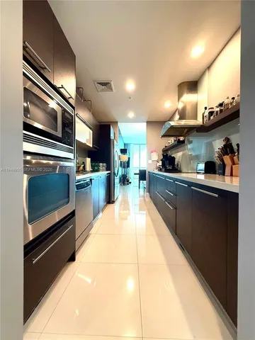 a kitchen with stainless steel appliances kitchen island granite countertop a stove a sink and a microwave