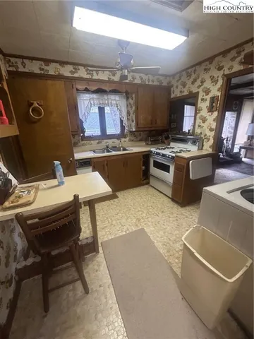 a living room with stainless steel appliances kitchen island granite countertop a sink and a stove