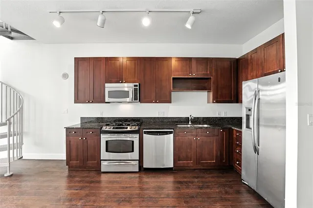 a kitchen with stainless steel appliances granite countertop a stove a refrigerator and a cabinets
