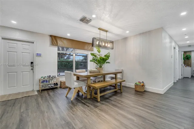 a living room with furniture a wooden floor and next to a window