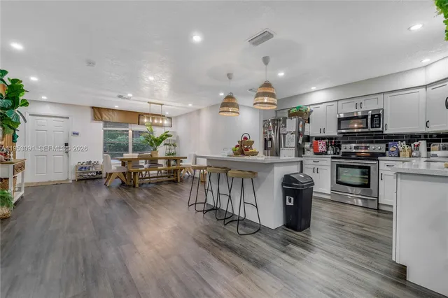 a living room with kitchen island furniture and a chandelier