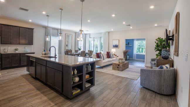 17641 Northwest 168th Road Alachua, FL 32615 - Photo 4 of 19 a living room with stainless steel appliances kitchen island granite countertop wooden floors and a view of living room