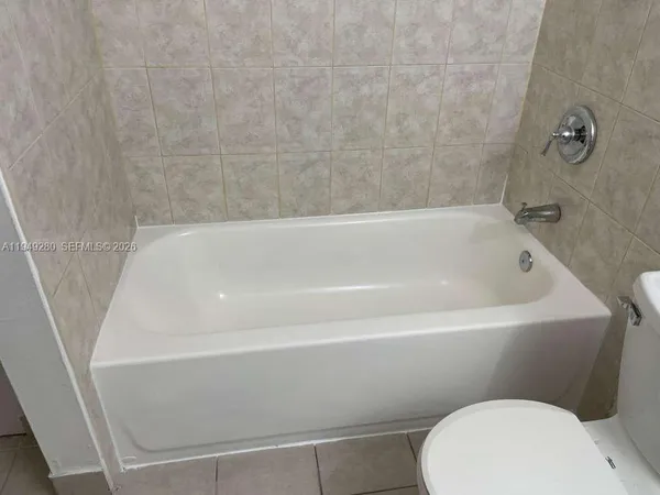 a bathroom with a white toilet and bathtub