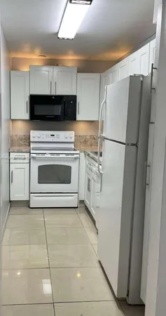 a kitchen with stainless steel appliances a refrigerator sink and cabinets