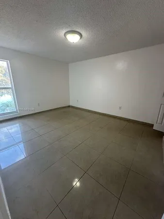 a view of a room with an empty space and window