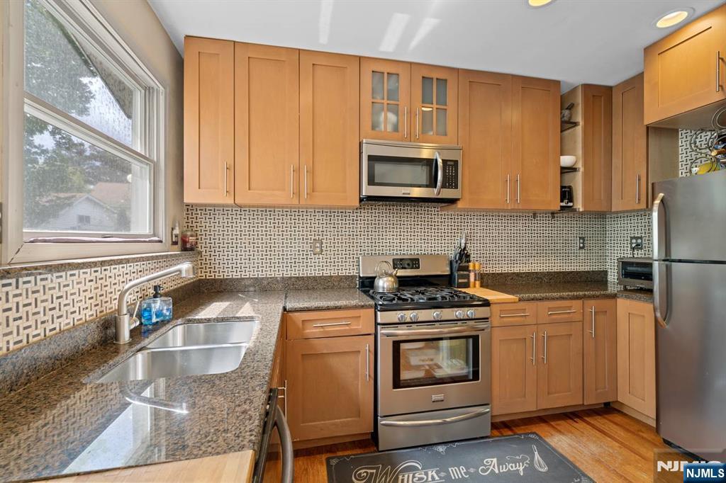 294 Sylvan Street Rutherford, NJ 07070 - Photo 11 of 29 a kitchen with stainless steel appliances granite countertop a stove a sink and a microwave