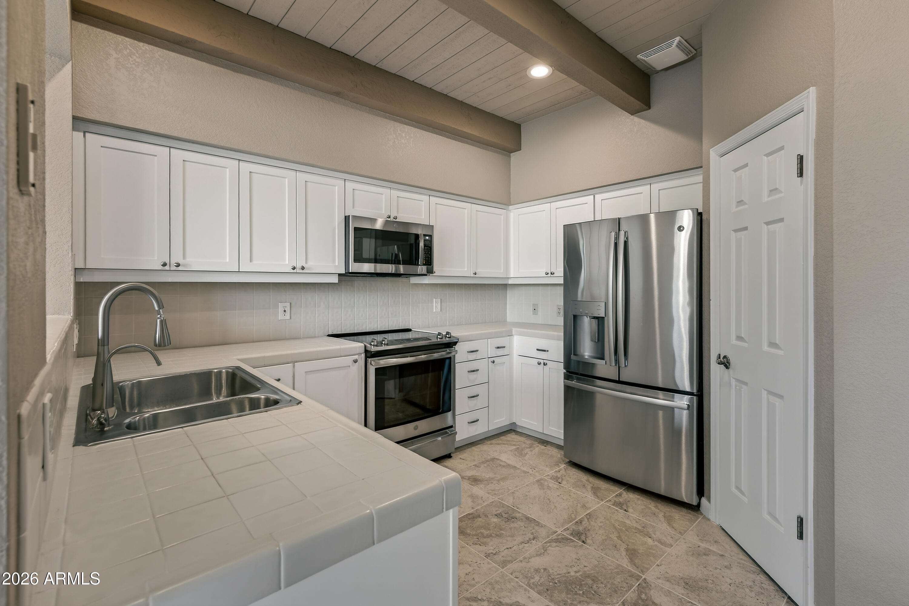 56 Red River Road Sedona, AZ 86351 - Photo 17 of 48 a kitchen with refrigerator a microwave a sink and cabinets