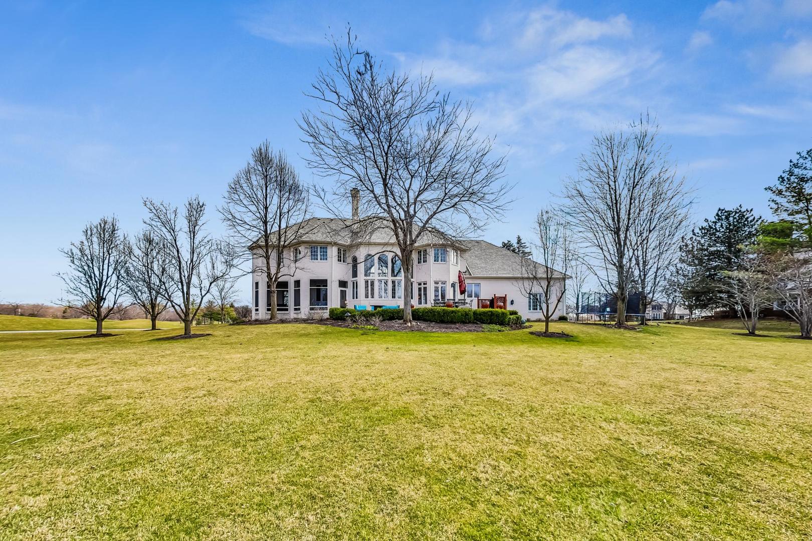 4454 Kettering Drive Long Grove, IL 60047 - Photo 39 of 44 a front view of house with swimming pool and trees in the background