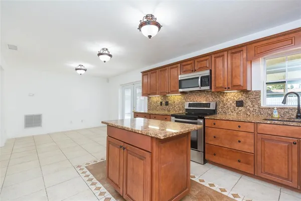 a kitchen with granite countertop a stove top oven a sink dishwasher and a microwave oven on the blue kitchen countertops