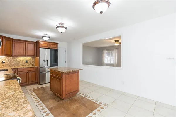 a kitchen with stainless steel appliances granite countertop a stove a refrigerator and a microwave oven