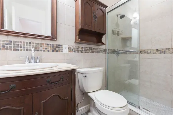 a bathroom with a sink a toilet and shower