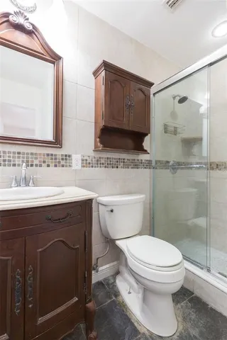 a bathroom with a sink a toilet and shower
