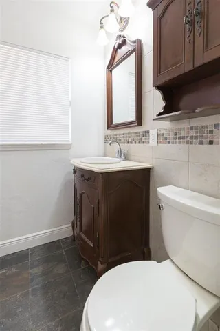 a bathroom with a toilet a sink and mirror