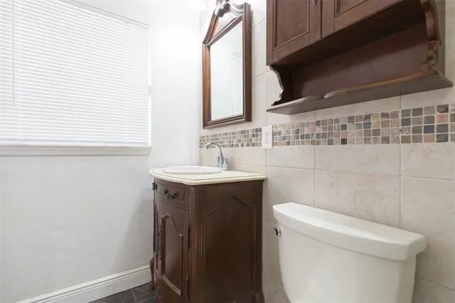 a bathroom with a sink a toilet and a mirror