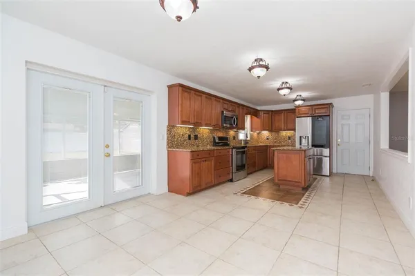 a kitchen with stainless steel appliances granite countertop a refrigerator and a sink