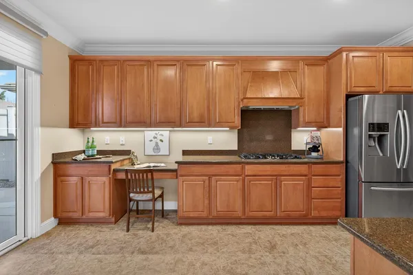 a kitchen with stainless steel appliances granite countertop a refrigerator a stove and a sink