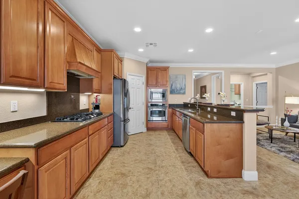 a large kitchen with stainless steel appliances granite countertop a stove a sink and a refrigerator