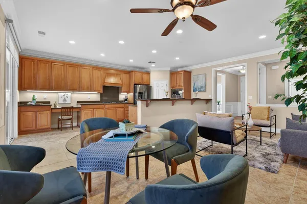 a kitchen with stainless steel appliances kitchen island granite countertop a dining table chairs microwave and sink
