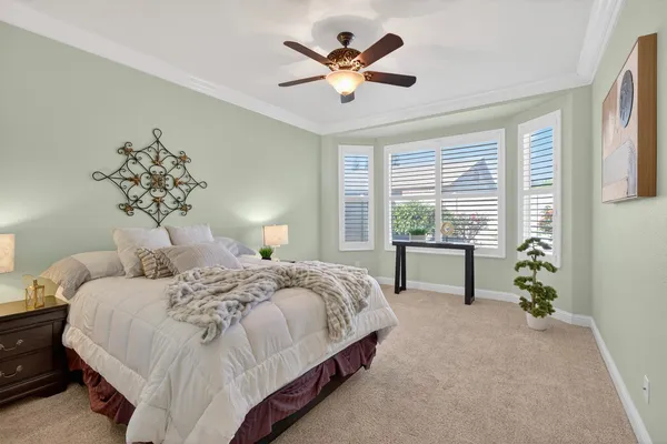 a bedroom with a bed and a chandelier fan