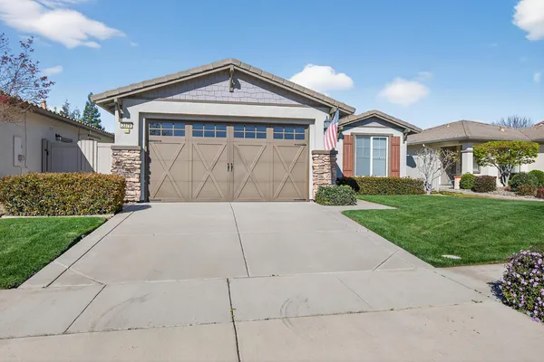a front view of a house with a yard and garage