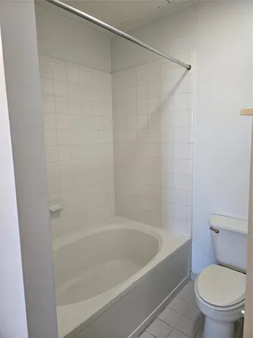 a white bath tub sitting next to a toilet