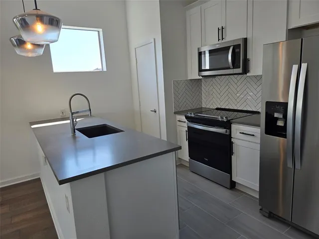 a kitchen with stainless steel appliances a microwave a sink and a refrigerator