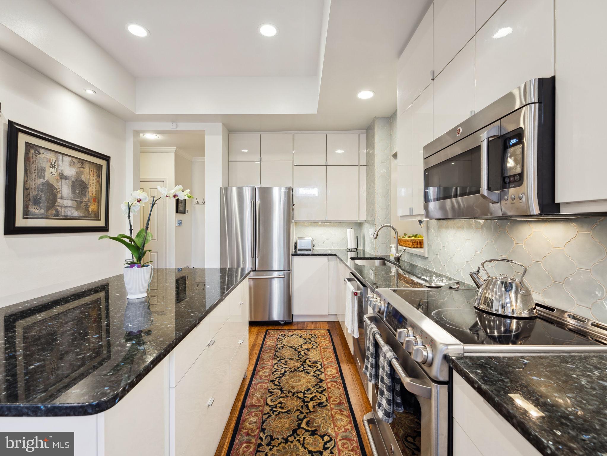 2001 19th Street Northwest, Unit 4 Washington, DC 20009 - Photo 14 of 42 a kitchen with stainless steel appliances granite countertop a stove a sink and a microwave