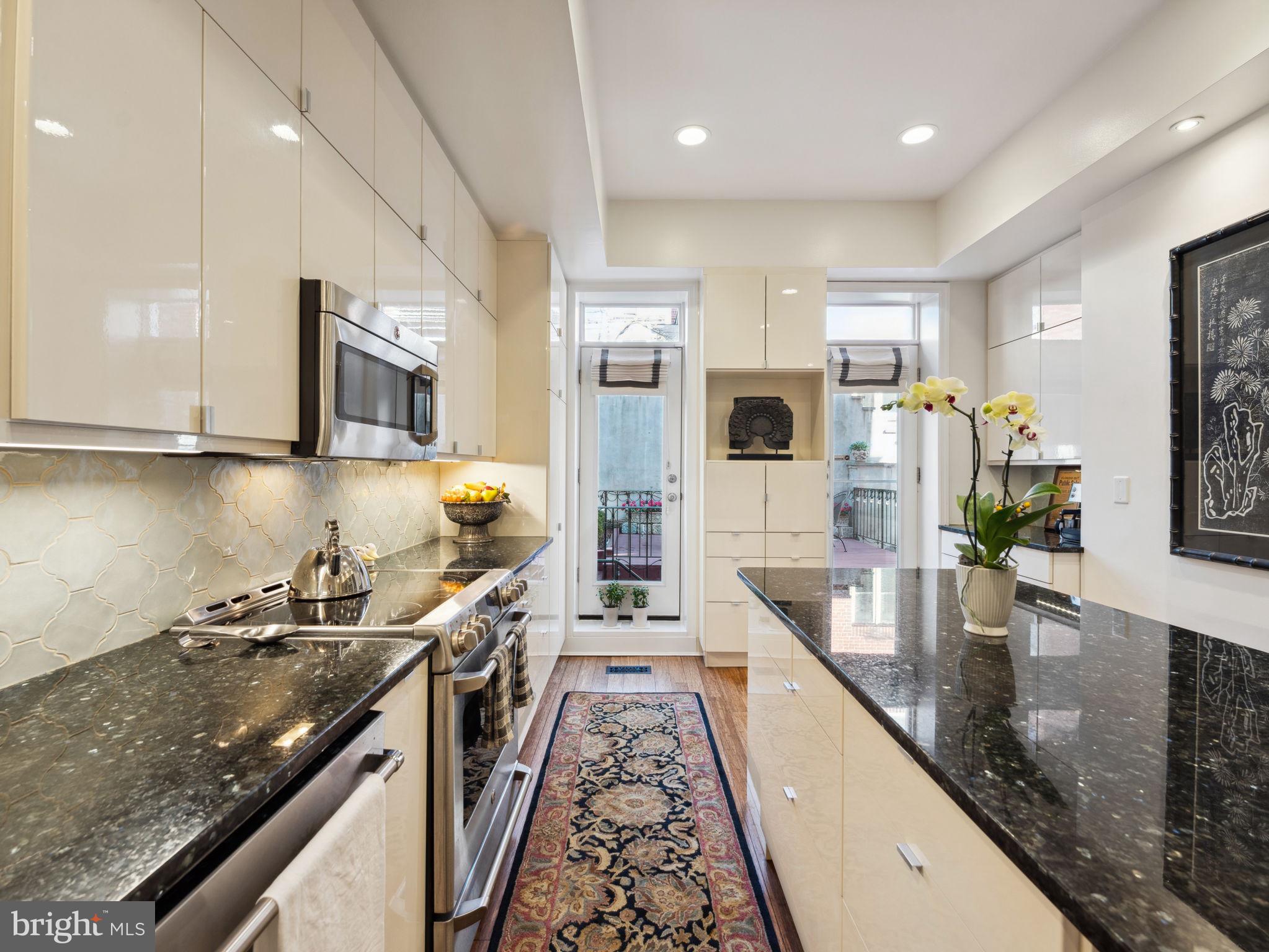 2001 19th Street Northwest, Unit 4 Washington, DC 20009 - Photo 18 of 42 a kitchen with stainless steel appliances granite countertop a sink a stove top oven a counter space and cabinets