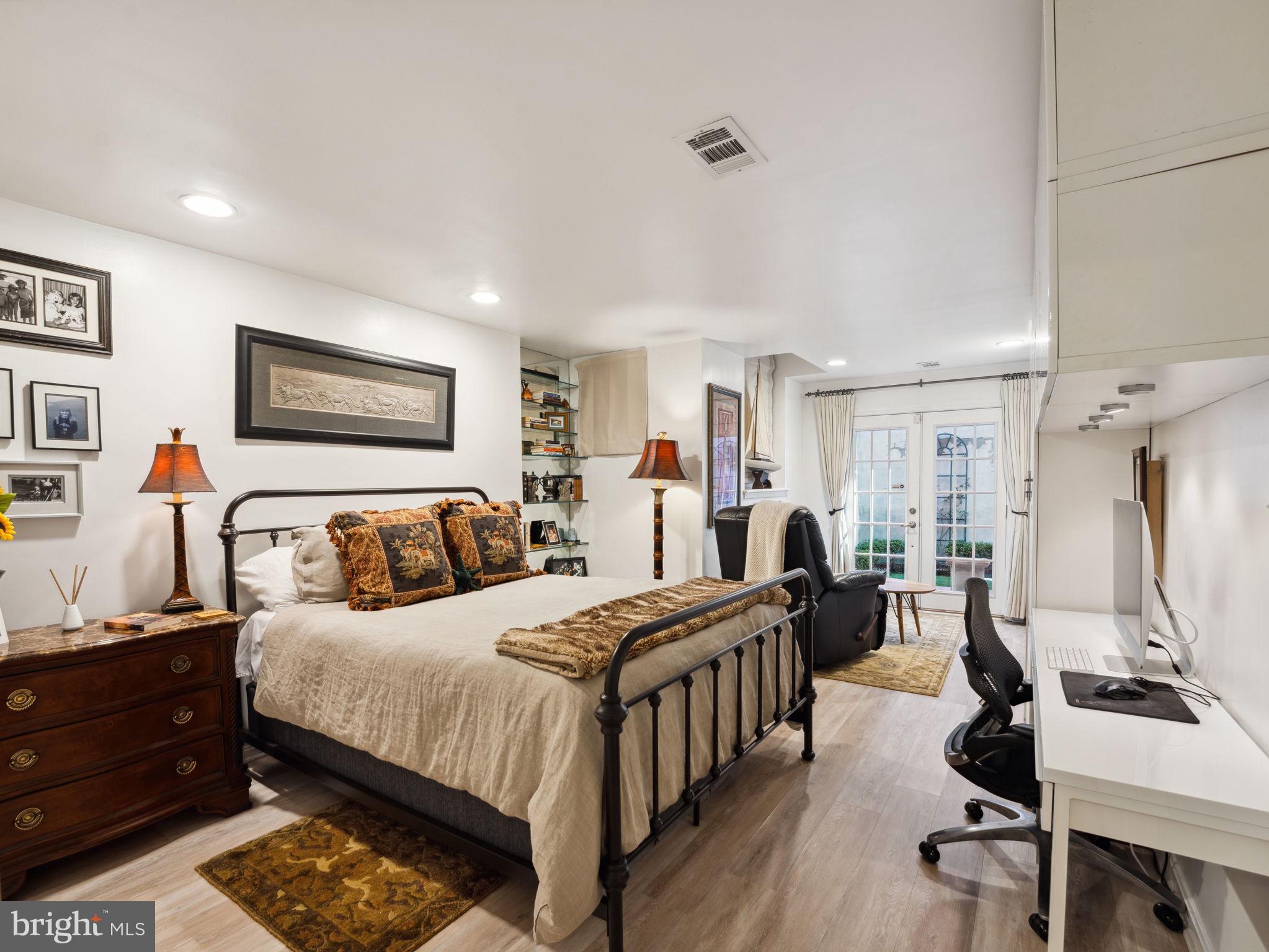 2001 19th Street Northwest, Unit 4 Washington, DC 20009 - Photo 28 of 42 a bedroom with a bed a couch and a flat tv screen on the dresser