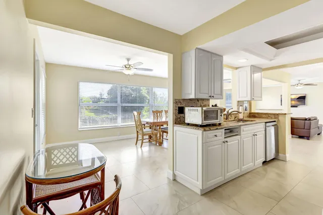 a living room with stainless steel appliances kitchen island granite countertop furniture and a large window