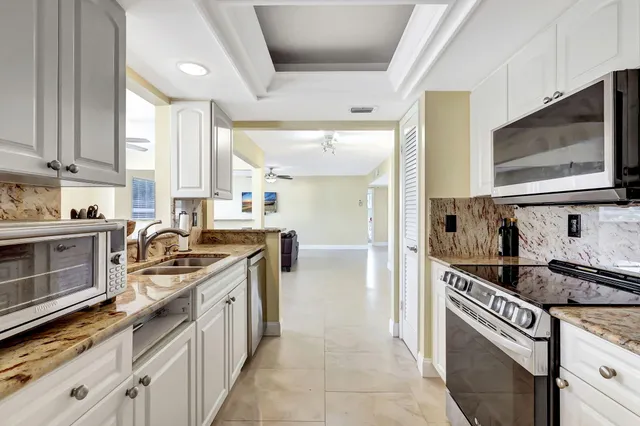 a kitchen with stainless steel appliances granite countertop a sink stove and cabinets
