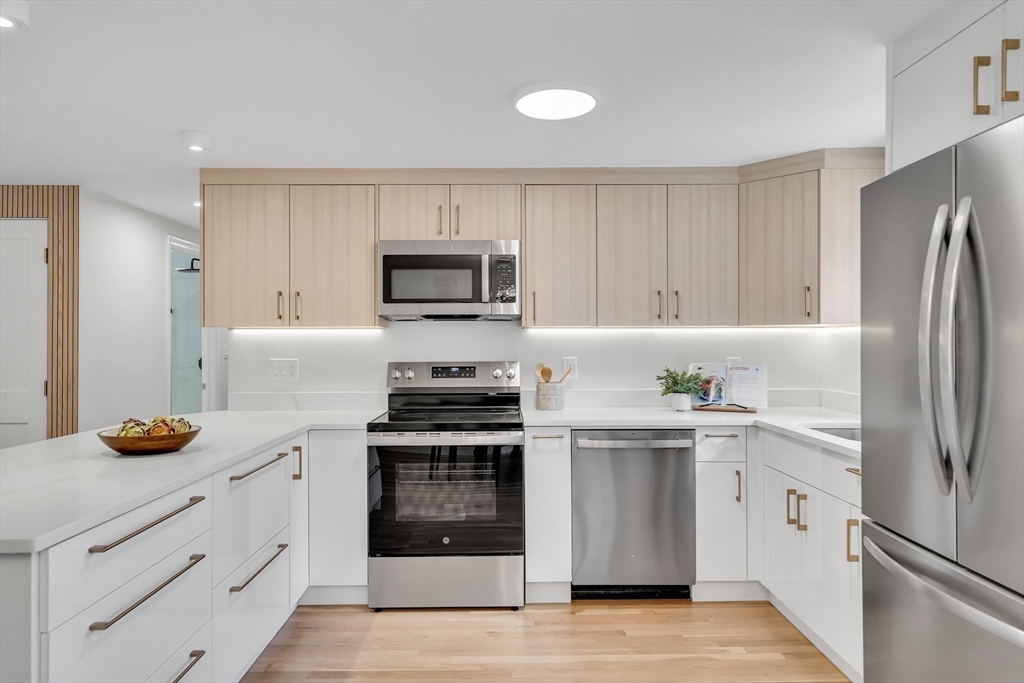 544 Pearl Street Reading, MA 01867 - Photo 5 of 24 a kitchen with white cabinets and stainless steel appliances